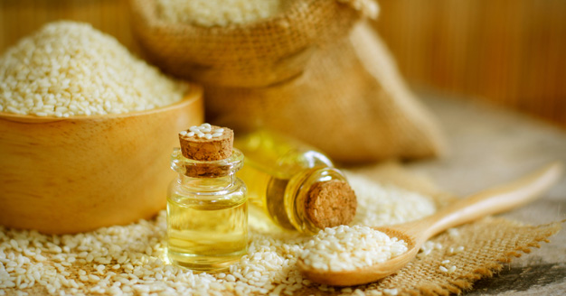 sesame seeds and oil with corked bottles on a table